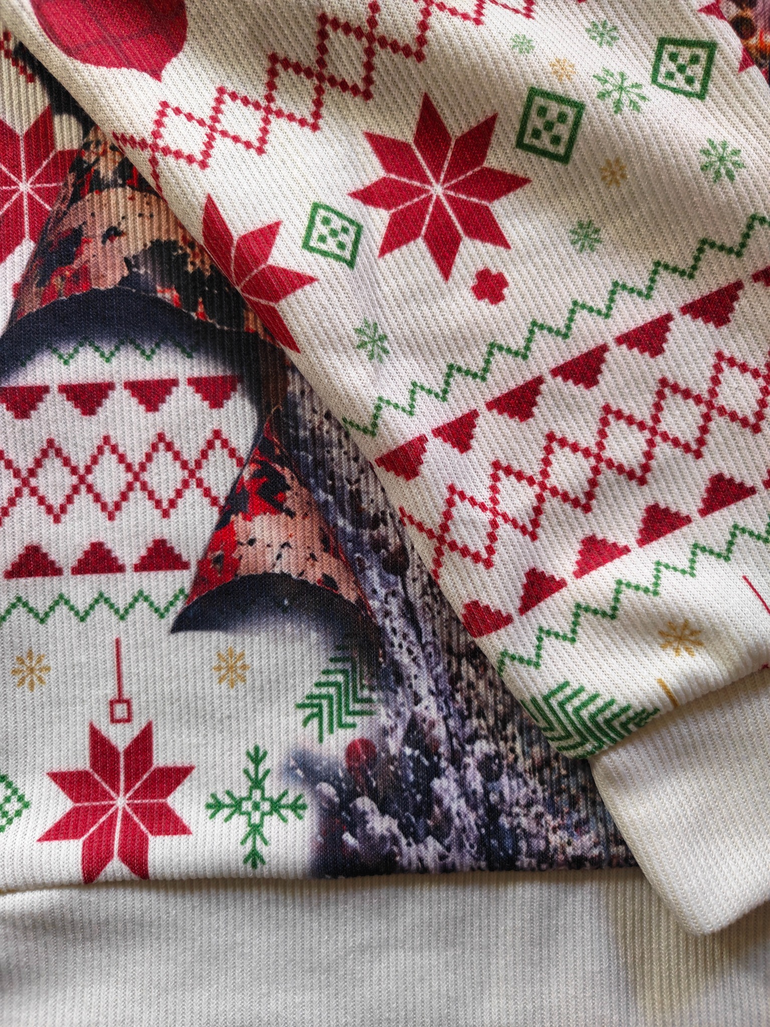 Close-up of our actual sweater showing the knit texture, Christmas print, sleeve cuff and bottom hem